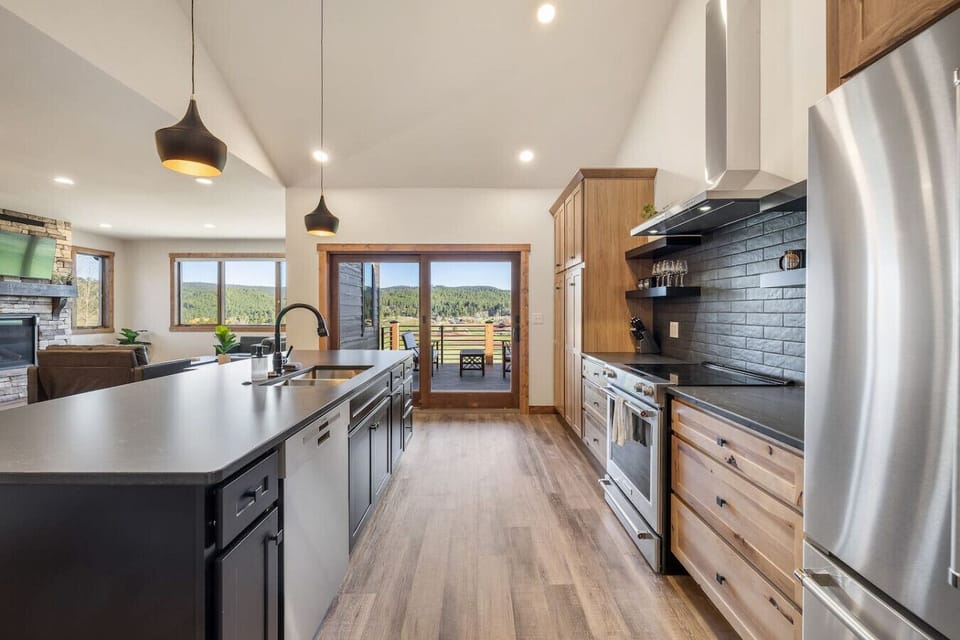Open the large glass doors to step onto the patio and take in the beautiful scenery — a seamless indoor-outdoor experience that’s perfect for entertaining or simply relaxing in nature’s beauty.