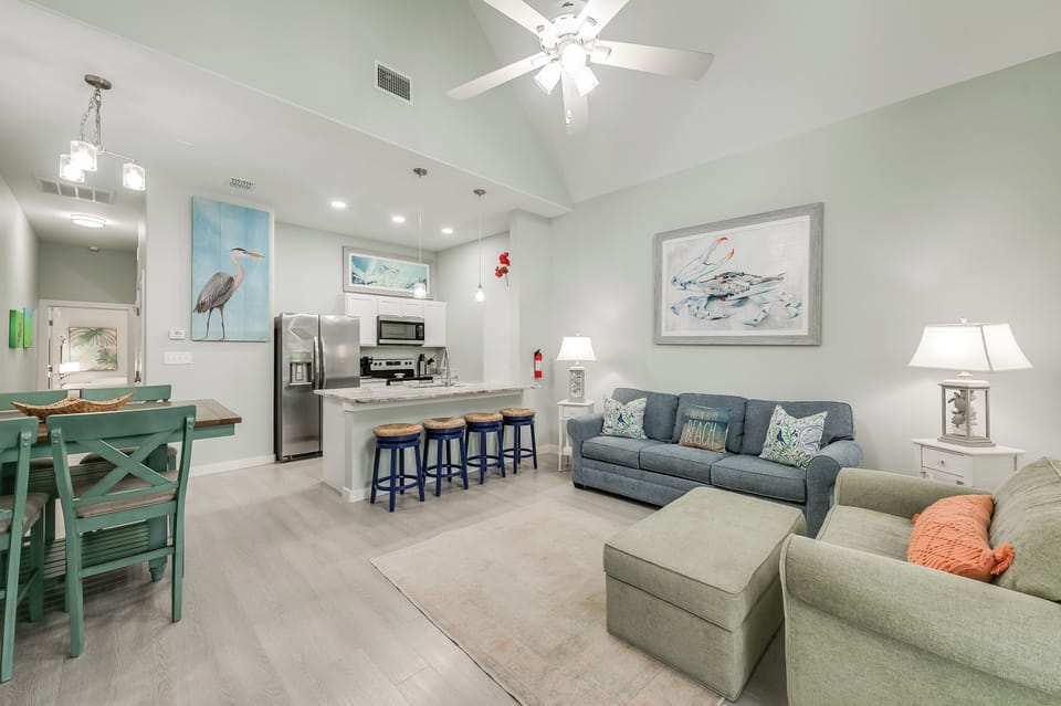Your bright, open living space blends kitchen and lounge with coastal touches and modern comfort for perfect vacation relaxation.