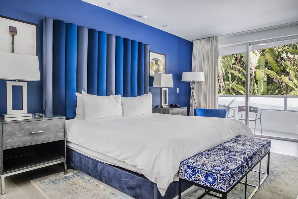 Relax in bright coastal style with balcony views and soft drapes.
