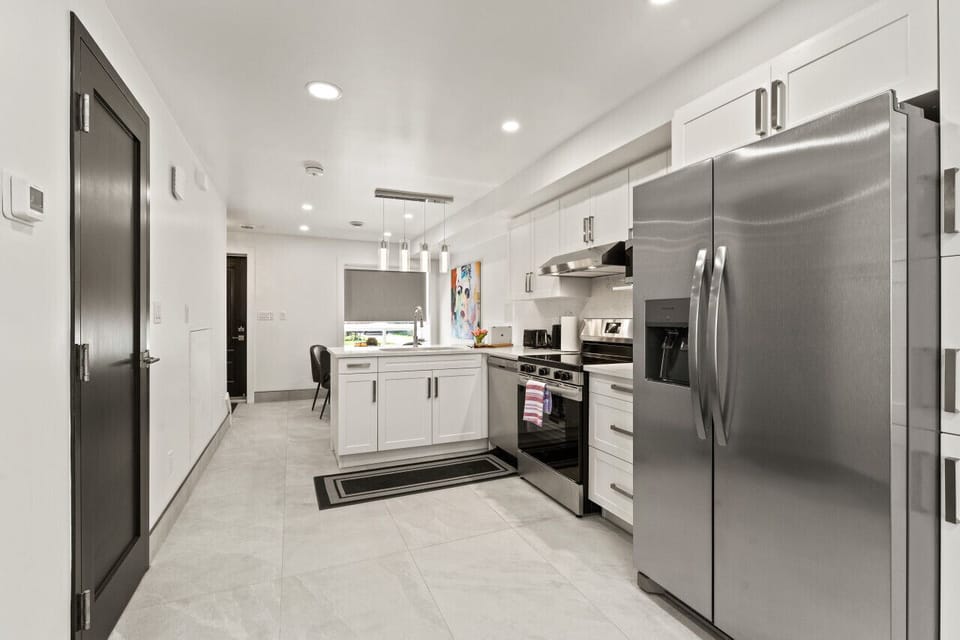 Sleek white cabinetry contrasts beautifully with dark wood floors.