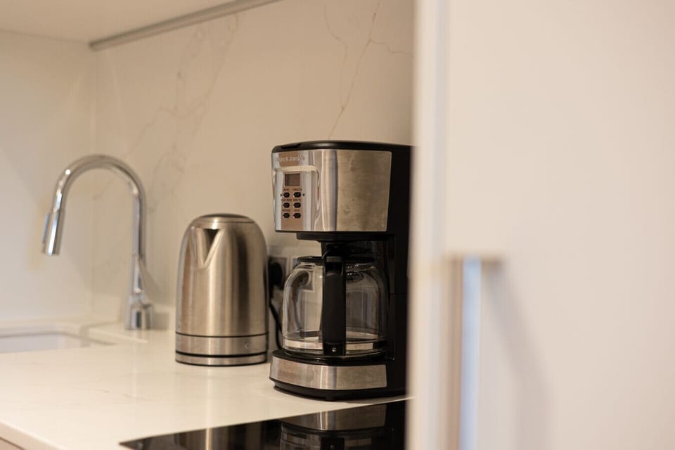 Coffee maker and electric kettle in a sleek kitchenette – start your seaside mornings with a fresh cup of coffee.