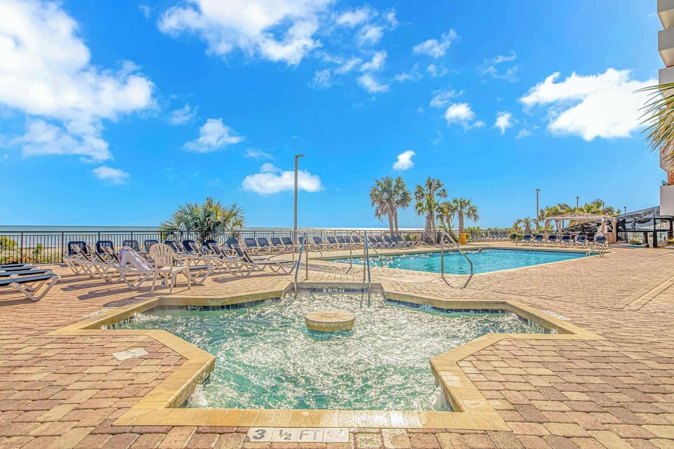 Relax under sunny skies at our oceanfront pool and hot tub area! Enjoy sweeping views, lounge chairs, and gentle sea breezes—your perfect Myrtle Beach vacation awaits.