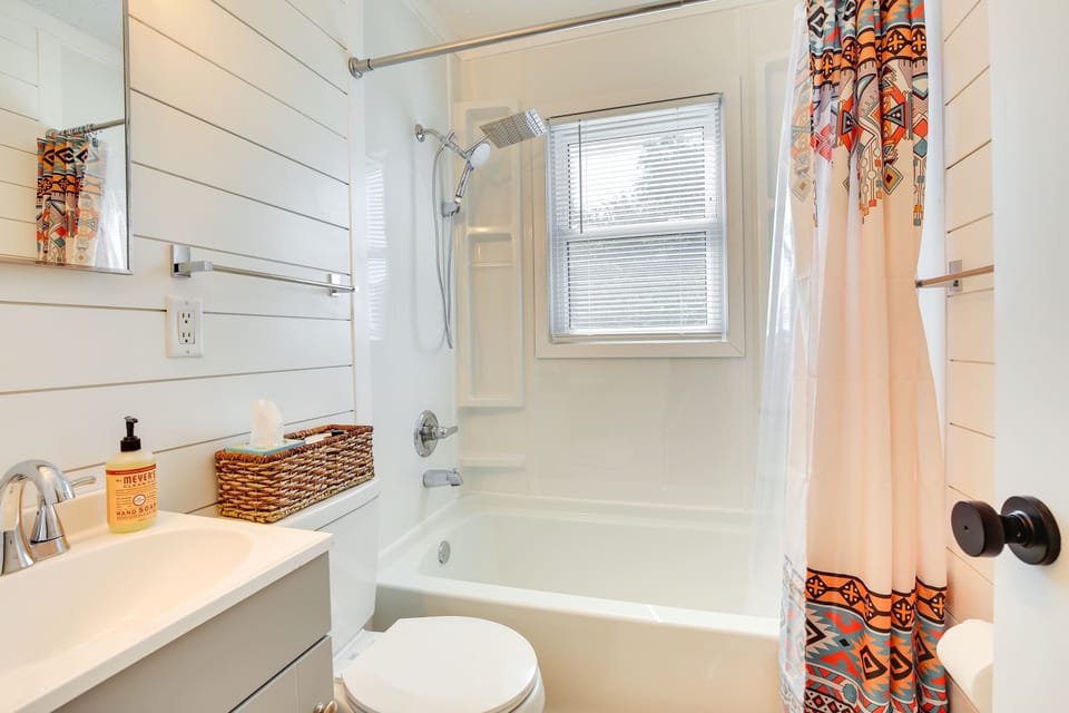 Unwind in a spa-inspired bathroom featuring a deep soaking tub, modern shower, and natural light from a stylish window.