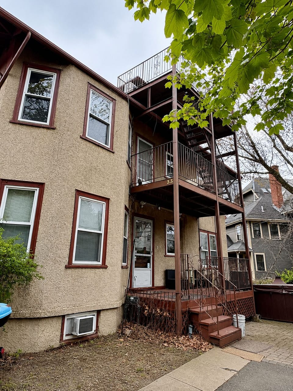 Charming exterior with private entry, balconies, and leafy surroundings