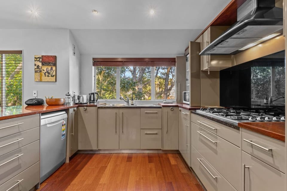 The kitchen has a dishwasher, microwave, gas cooktop, oven, and fridge/freezer.