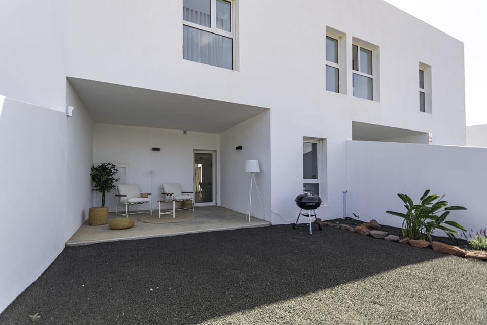 Spacious back terrace with relaxation area and barbecue for outdoor enjoyment.