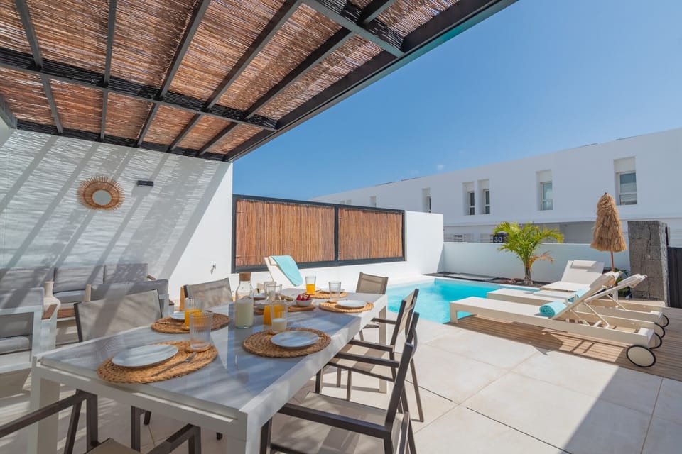 Terrace with outdoor dining area next to the pool.