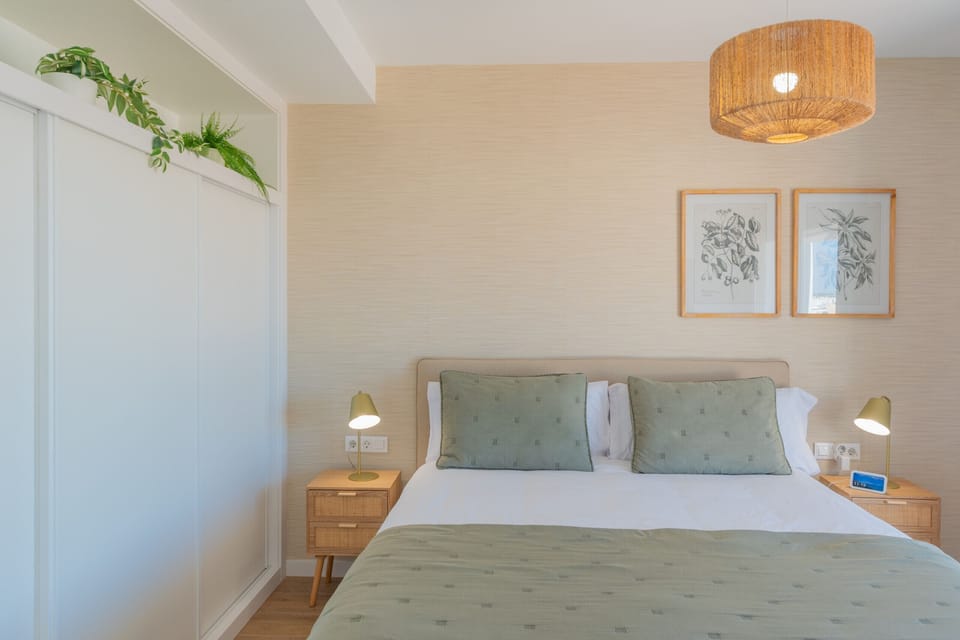 Spacious master suite with large bed and relaxing green tones.