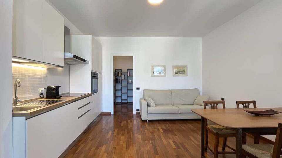 Open space with modern kitchen, living room with comfortable sofa and TV, perfect for relaxing moments in a contemporary atmosphere.