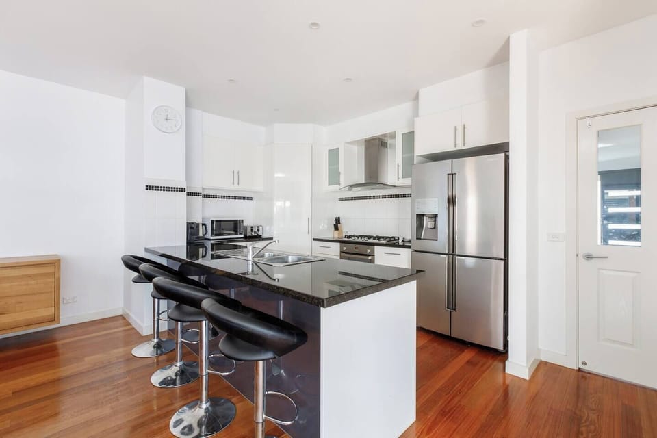 Whip up your favourite meals in the compact yet efficient kitchen, featuring a gas cooktop, oven, dishwasher, and a stone benchtop with bar seating for casual bites.