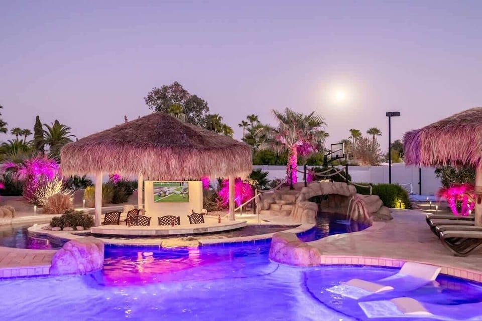 Pool and palapa area lit up at night with color-changing LEDs to set up the modod