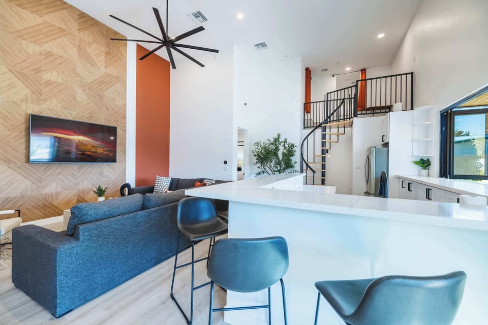 High ceilings and blue bar stools create a space that feels open and connected