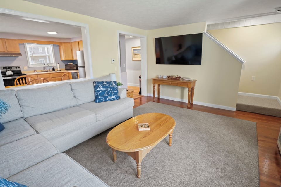 Coastal-style living room with comfy seating and 65" smart TV for streaming.