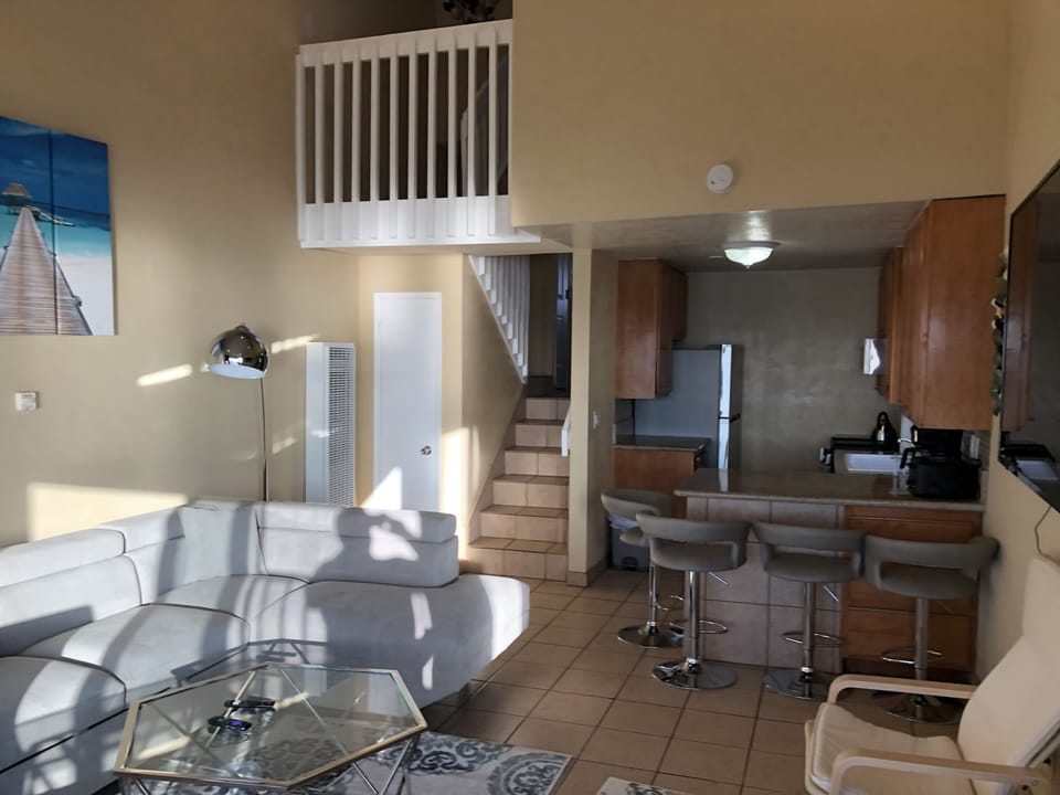 Kitchen adjoining living room and stairs to entry level and bedrooms