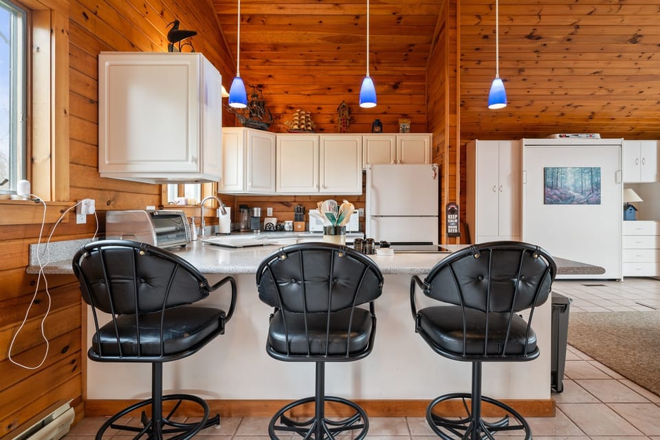 Enjoy a spacious and modern kitchen with sleek black bar stools, perfect for casual dining and socializing.