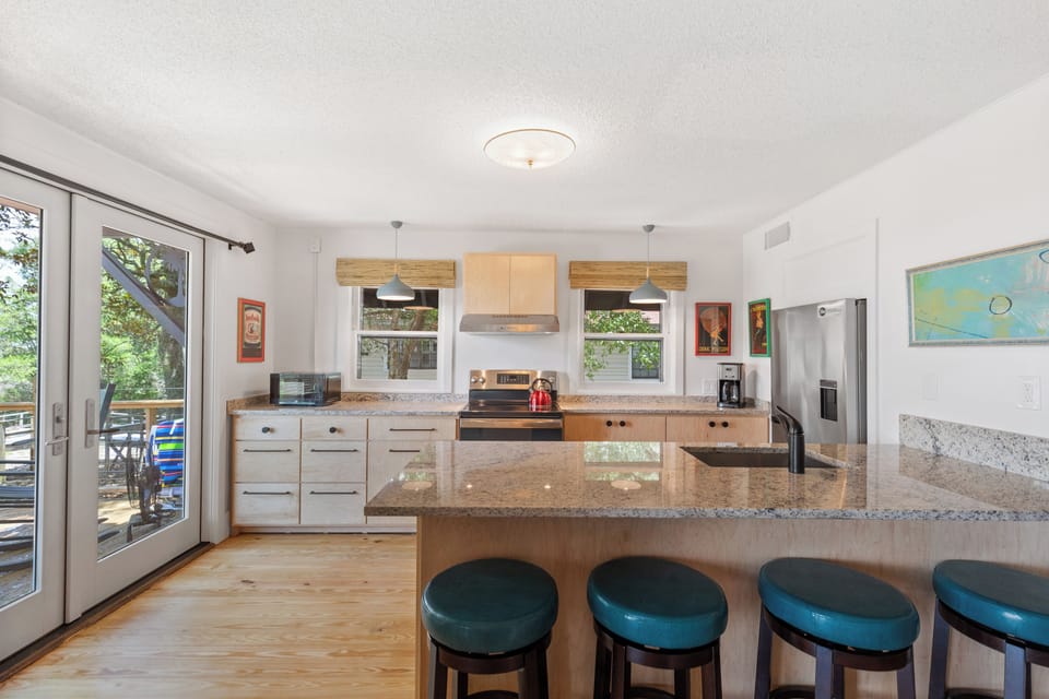 The kitchen in the home boasts a four person breakfast bar, updated appliances, and french doors leading to the spacious deck.