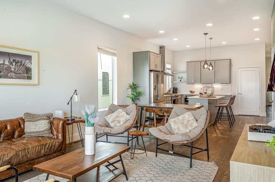 Unit 1: Welcoming living area with a vibrant green accent wall, large Smart TV, and plush seating arranged to take in the serene outside views.