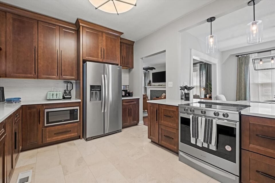 Enjoy a fully stocked, modern kitchen featuring stainless steel appliances, rich wood cabinetry, and everything you need for home-cooked meals during your Hyde Park stay.