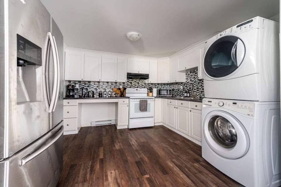 Cook delicious meals in the fully equipped kitchen featuring modern appliances. Enjoy the convenience of in-unit laundry, making longer stays a breeze. Everything you need for a comfortable and self-sufficient trip.