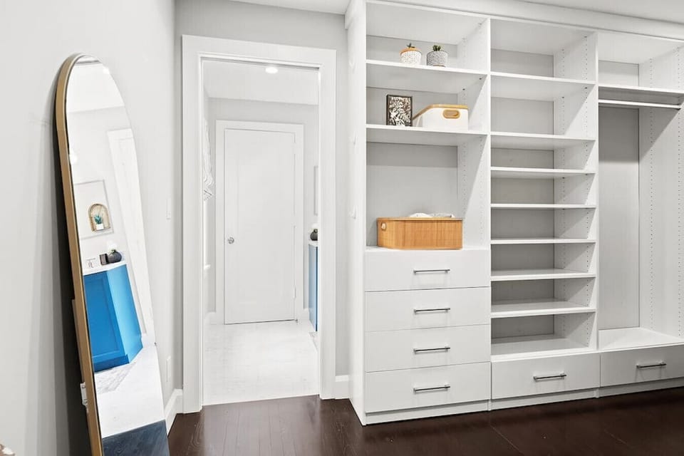Organized walk-in closet offers ample shelving, drawers, and hanging space for easy storage.
