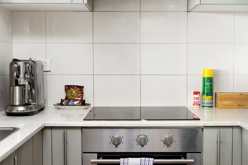 Cook efficiently in a well-appointed kitchen space showcasing a sleek stovetop and oven set into a practical countertop, ready for your culinary endeavors.