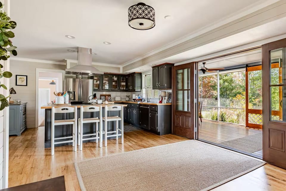 Screened-in front porch extends large kitchen living space.