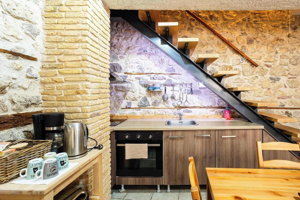 Fully Equipped Kitchen with Wooden Staircase and Dining Area