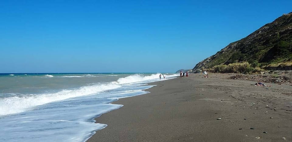 Agios Georgios Beach – Unspoiled beach surrounded by lush greenery.