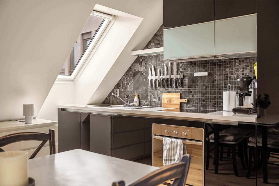 Sleek, dark cabinetry contrasts beautifully with the light countertops and mosaic backsplash.
