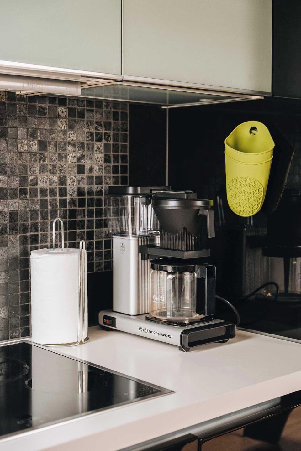 Modern kitchen appliances, including a coffee maker, are neatly arranged on the countertop.