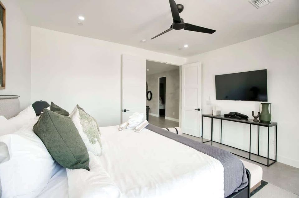 Bright loft bedroom with sleek railings overlooking the main living area below.