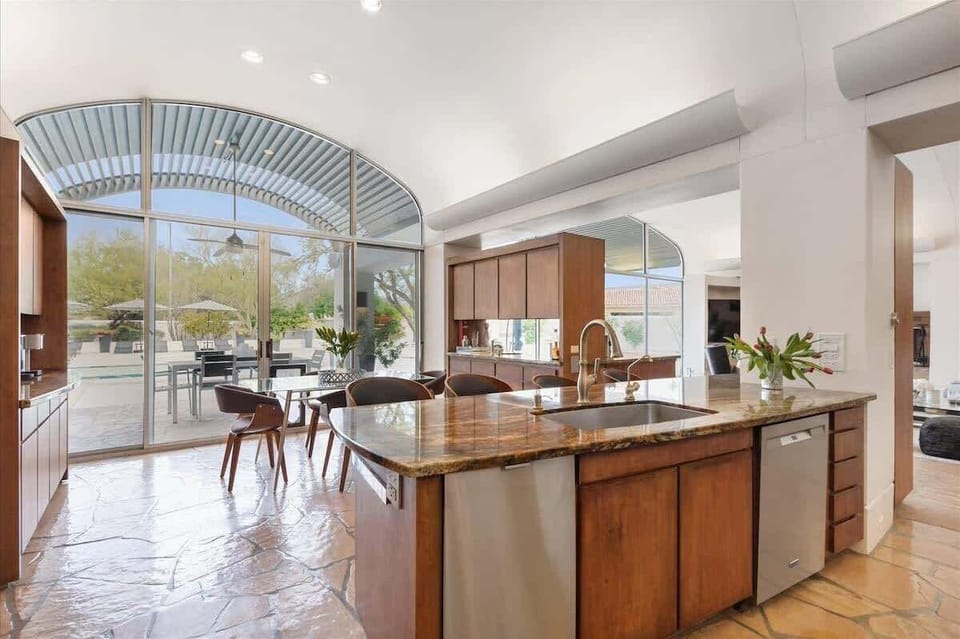 
Sleek modern kitchen with waterfall island and seamless indoor-outdoor flow