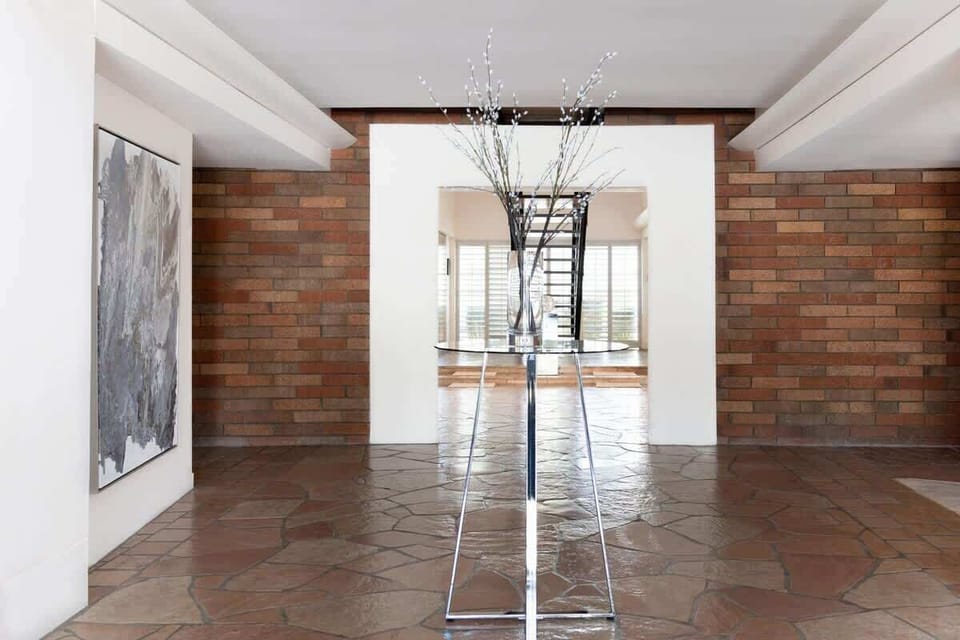 Grand entrance with floor-to-ceiling windows and striking wood accent walls