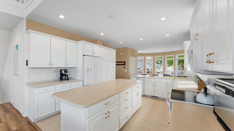 Main Floor Kitchen with Island, Electric Stove, Microwave, Refrigerator, Coffee maker and Kettle.