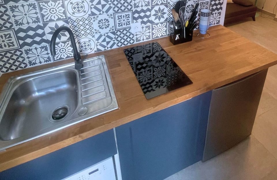 Cuisine du studio – Équipements modernes et ambiance cosy Plaque vitrocéramique, lave-vaisselle, rangements astucieux et décoration soignée pour un séjour sans contrainte au cœur de l’île de Ré.