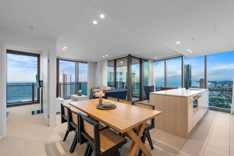 Spacious open living area surrounded by 180° floor-to-ceiling windows, offering breathtaking views of the ocean, hinterland, and city—flooded with amazing natural light.