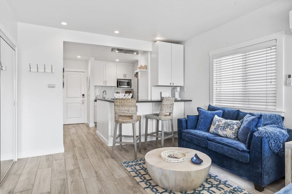 Bright, open living area with a cozy blue sofa and a modern kitchen.