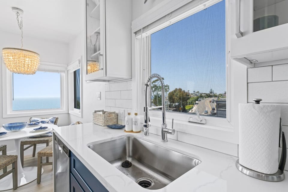 right kitchen sink area with a view of the lush greenery and ocean.
