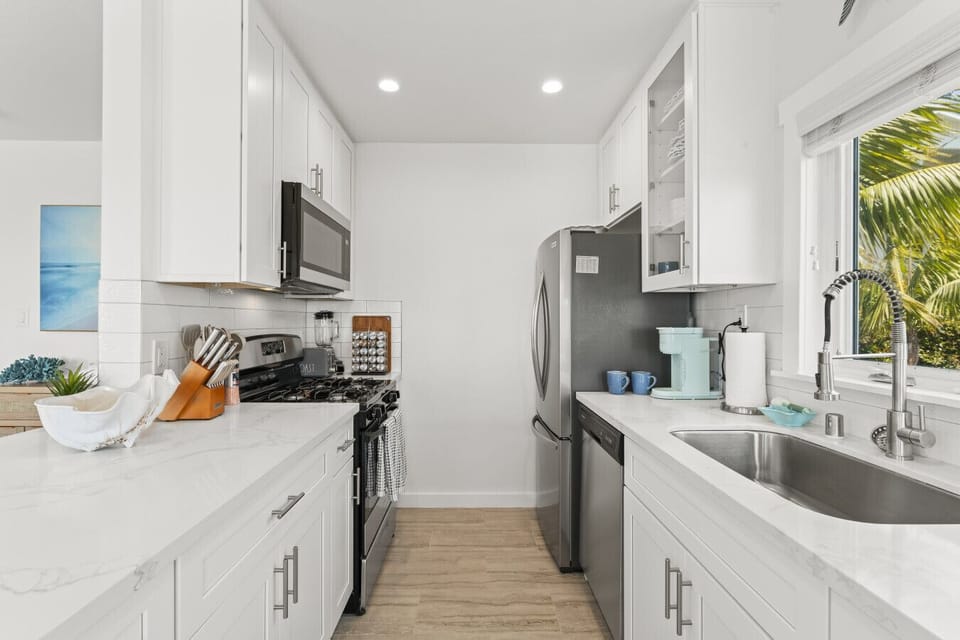 Well-equipped kitchen with a bright, coastal aesthetic.