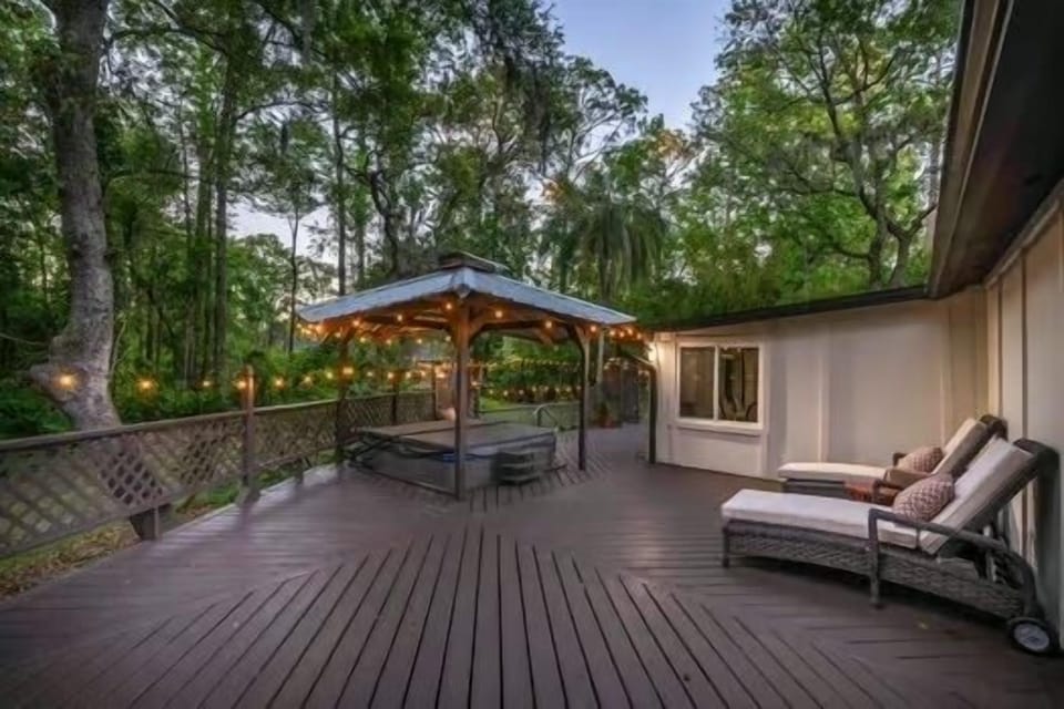 Massive deck with loungers and hot tub is off primary bedroom and family room