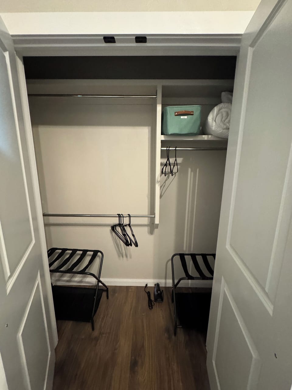 Luggage stand, extra bedding, and iron located in this closet. 