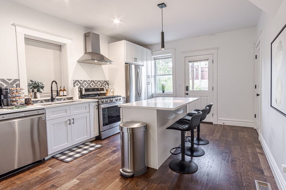 Whip up culinary delights in this modern kitchen with stylish island seating and sunny views!