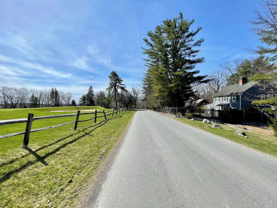 Road with house on right and golf course on left