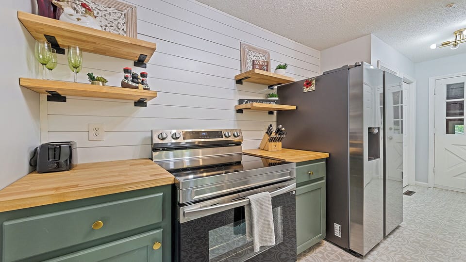 Bright kitchen with woodland views, gold fixtures, and cozy charm.