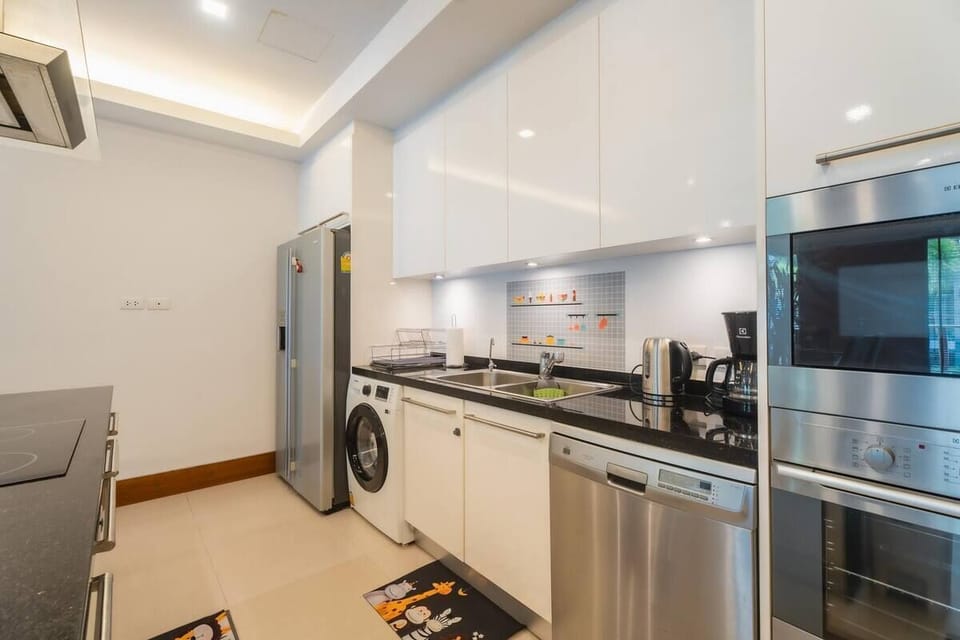 Fully equipped kitchen with refrigerator, oven, stovetop, microwave, and cookware.