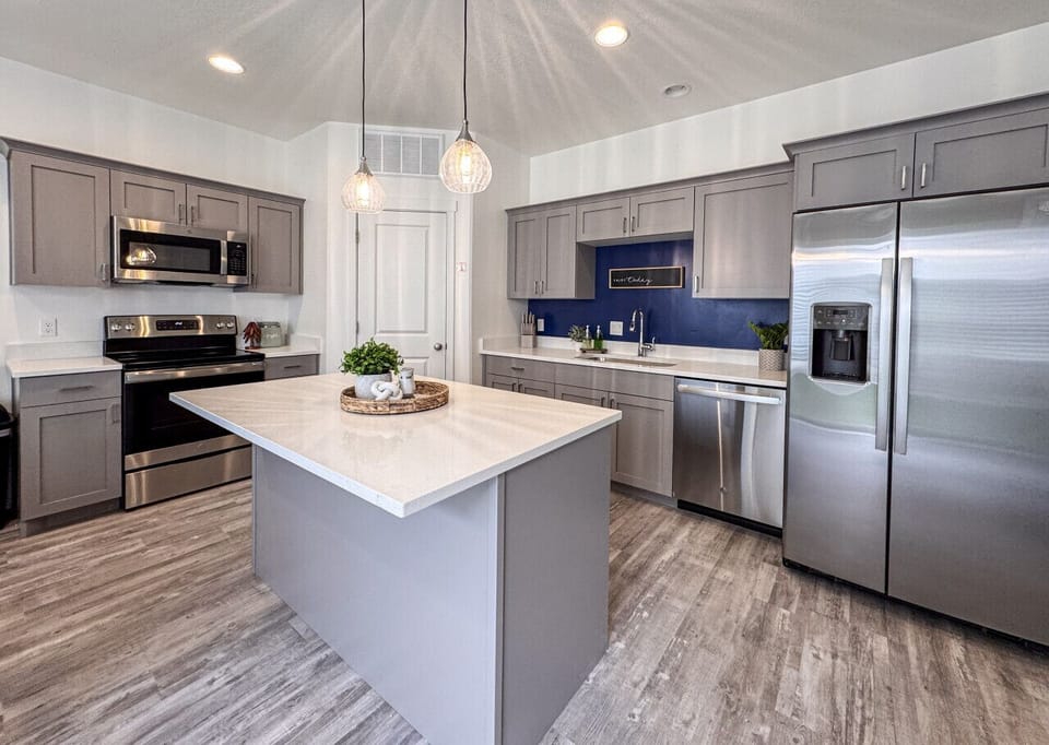 Sleek modern kitchen with quartz countertops, stainless steel appliances, and cozy pendant lighting accents.