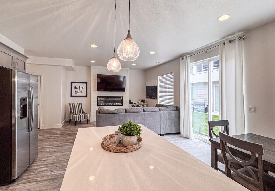 Bright open-concept living with cozy fireplace, plush seating, and seamless indoor-outdoor flow.