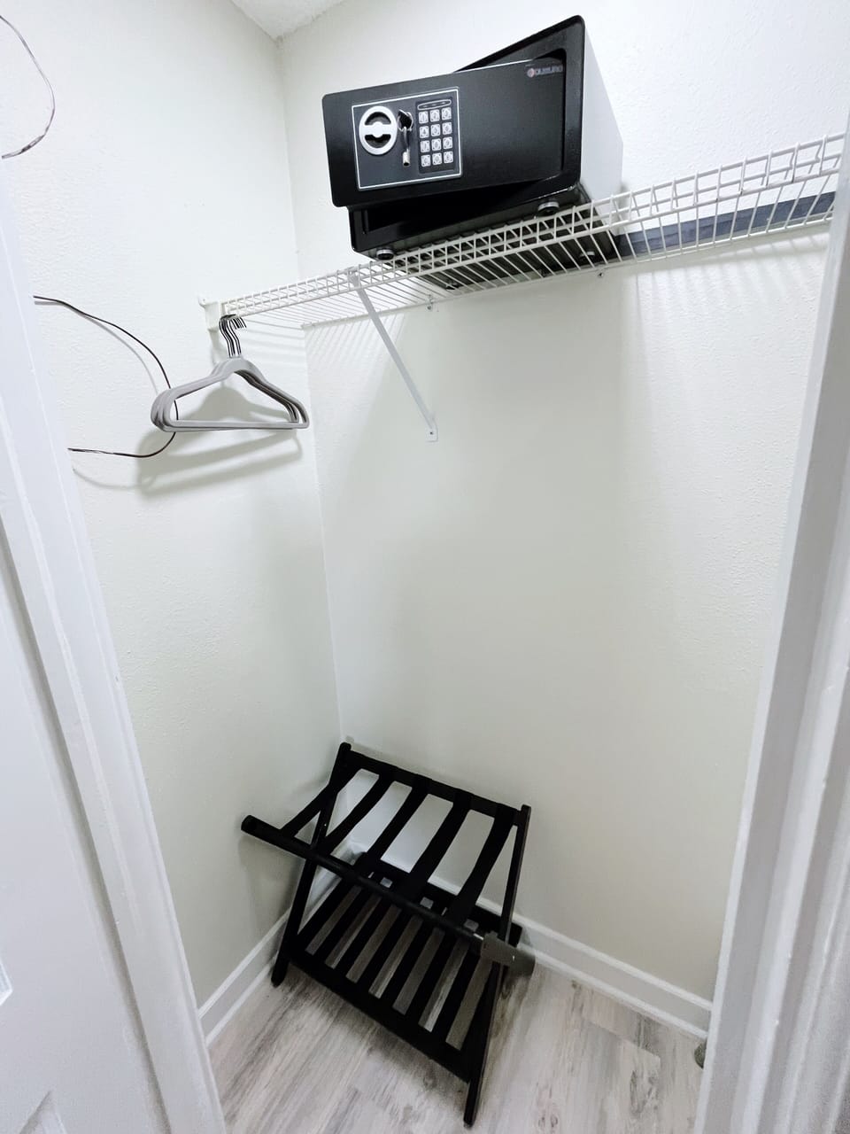 Spacious closet with a safe, luggage stand, and shower bench. 
