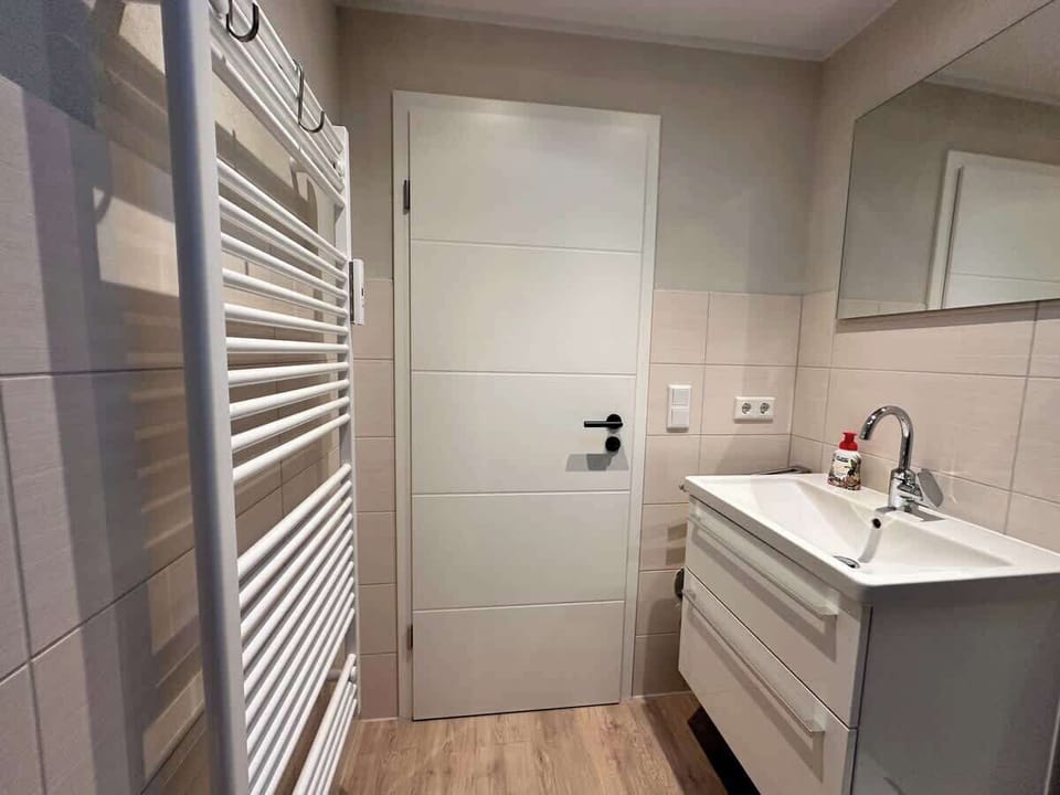 Modernes Badezimmer mit jede Menge Stauraum und Handtuchwärmer.