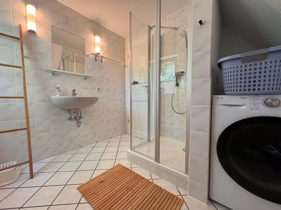 Badezimmer mit Dusche und Waschmaschine